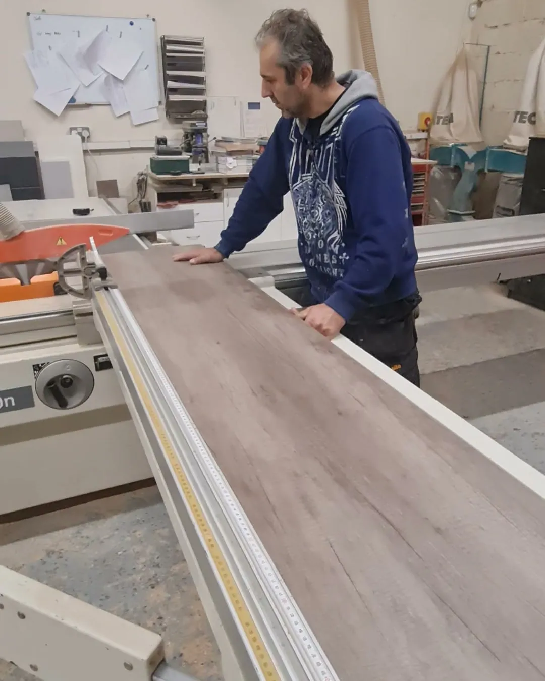 Cutting a grey oak woodgrain panel on the panel saw in the Lagoss workshop